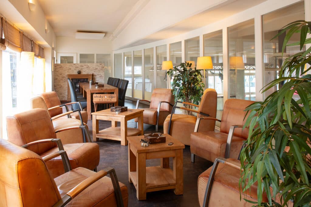 Blick in die Zigarren-Lounge auf der Empore des whisky & cigar salon, mit Sitzgruppen.