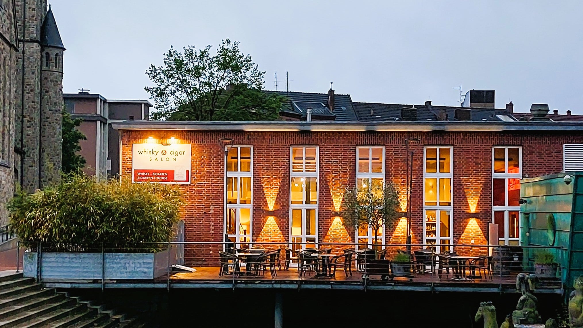 Blick auf das Gebäude zur Dinkelseite hin, in der Dämmerung angeleuchtet.